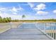 Back deck view of a pond surrounded by trees under a partially cloudy blue sky at Lot 40 Lineback Pl. # 40, Longs, SC 29568