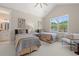 Bright bedroom featuring two twin beds, neutral decor, and a large window providing ample natural light at 405 N Highland Way, Myrtle Beach, SC 29572