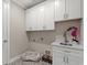 Well-equipped laundry room with white cabinetry, a sink, and tiled flooring at 405 N Highland Way, Myrtle Beach, SC 29572