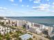 An aerial view showcasing the coastline and buildings near the beach under a picturesque blue sky at 7200 Ocean Blvd. N # 254, Myrtle Beach, SC 29572