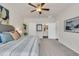 Bright bedroom featuring a ceiling fan, striped bedding, and an ensuite bathroom entrance at 4723 Huckleberry Ln., Conway, SC 29526