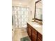 Well-lit bathroom with a single sink vanity, a large mirror, and a shower with a patterned curtain at 516 Papyrus Circle # 516, Little River, SC 29566