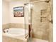 Elegant bathroom featuring a soaking tub and a separate glass-enclosed shower with beige tile at 516 Papyrus Circle # 516, Little River, SC 29566
