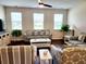 Cozy living room featuring stylish furniture, three large windows, and hardwood floors at 516 Papyrus Circle # 516, Little River, SC 29566