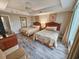 This bright bedroom features two beds, ceiling fan, and wood flooring at 9994 Beach Club Dr. # 205, Myrtle Beach, SC 29572