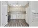 Kitchen with white cabinets, stainless steel appliances, and wood-look floors at 11 Valencia Circle, Myrtle Beach, SC 29572