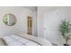 Bright bedroom with a round mirror, plant, and soft carpet; great natural light and calming aesthetic at 318 Cheerful Way, Little River, SC 29566
