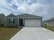 Charming single-story home showcasing a well-manicured lawn, a two-car garage and neutral-toned exterior paint at 318 Cheerful Way, Little River, SC 29566