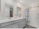 Modern bathroom with double vanity, gray cabinets, and a shower with a patterned curtain at 3851 Lady Bug Dr., Shallotte, NC 28470