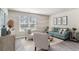 Living room with teal sofa, white armchairs, and gray wood-look floors at 3851 Lady Bug Dr., Shallotte, NC 28470