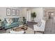 Living room with teal sofa, white armchair, and glass coffee table at 3851 Lady Bug Dr., Shallotte, NC 28470