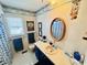 Bright bathroom with blue accents, floral wallpaper, and a vanity with an oval mirror at 6001 - 5410 S Kings Hwy., Myrtle Beach, SC 29575