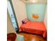 A bright bedroom with a twin bed, orange bedding, and an octopus picture at 6001 - 5410 S Kings Hwy., Myrtle Beach, SC 29575