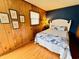 A cozy bedroom with wood-paneled walls, a full bed with nautical-themed bedding, and natural light at 6001 - 5410 S Kings Hwy., Myrtle Beach, SC 29575