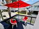 Relaxing deck with a red umbrella, perfect for outdoor dining and enjoying coastal living at 6001 - 5410 S Kings Hwy., Myrtle Beach, SC 29575