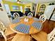 A sunny dining area with a wood table, six chairs, and a vibrant yellow wall at 6001 - 5410 S Kings Hwy., Myrtle Beach, SC 29575