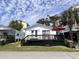 Charming white cottage with black deck and a bright red umbrella for a vibrant, inviting look at 6001 - 5410 S Kings Hwy., Myrtle Beach, SC 29575