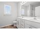 Well-lit bathroom features a double sink vanity, large mirror, and shower with white tiled walls at 1124 Cypress Shoal Dr., Conway, SC 29526