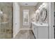 Bathroom featuring a tiled shower, double vanity, decorative mirrors, and natural light at 4989 Salt Creek Ct., North Myrtle Beach, SC 29582