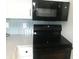 Kitchen featuring black appliances, white cabinets and sleek counter tops with a decorative tile backsplash at 7100 N Ocean Blvd. # 1023, Myrtle Beach, SC 29572