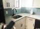 The kitchen features white cabinets, light countertops, a black faucet, and a unique tile backsplash at 7100 N Ocean Blvd. # 1023, Myrtle Beach, SC 29572