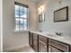 Bright bathroom featuring a double sink vanity, framed mirrors, and a large window at 1348 Peterson St., Myrtle Beach, SC 29577