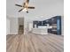 Open-concept kitchen featuring wood floors, staircase, ceiling fan, and modern navy cabinets at 569 Beckham Ct., Murrells Inlet, SC 29576