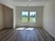 Bright living room with wood-look floors and large windows offering a view of the outdoors at 2275 King Farm Rd., Aynor, SC 29511