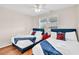 Charming bedroom featuring two twin beds with red accents, bright natural light, and hardwood flooring at 404 32Nd Ave. N, North Myrtle Beach, SC 29582