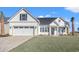 White farmhouse exterior with a two-car garage and a nicely landscaped lawn at 1409 Crooked Hook Rd., North Myrtle Beach, SC 29582