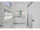 Bright bathroom featuring a large window, white vanity, and shower with patterned glass door at 9318 Cove Dr., Myrtle Beach, SC 29572