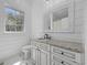 Well-lit bathroom featuring a granite countertop vanity, decorative mirror, and a walk-in shower at 9318 Cove Dr., Myrtle Beach, SC 29572
