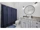 Clean bathroom featuring a granite countertop, large mirror, and walk-in shower with a navy blue shower curtain at 9318 Cove Dr., Myrtle Beach, SC 29572