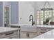 Kitchen island with a farmhouse sink, white cabinets, and counter-depth dishwasher at 9318 Cove Dr., Myrtle Beach, SC 29572