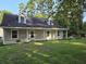 Charming home with a quaint front porch and dormer windows, surrounded by lush greenery at 938 Fox Hollow Rd., Conway, SC 29526