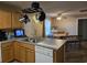 Well-lit kitchen featuring wood cabinets, stainless steel sink, and dining area beyond the kitchen island at 938 Fox Hollow Rd., Conway, SC 29526
