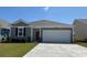 Charming single-story home with gray siding, a red front door, and a spacious two-car garage at 559 Duvall St., Longs, SC 29568