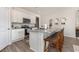 Bright kitchen with a granite-topped island, stainless steel appliances, white cabinets, and seating for casual dining at 573 Duvall St., Longs, SC 29568