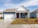 Charming blue single-story home with a well-manicured lawn and attached garage, perfect for suburban living at 576 Duvall St., Longs, SC 29568