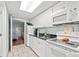 Clean kitchen with white appliances and cabinets, granite countertops, and a view into a well-lit bedroom at 2000 N Ocean Blvd. # 1612, Myrtle Beach, SC 29577