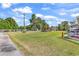 Large grassy backyard with mature trees and a small backyard patio with furniture at 3747 Bakers Chapel Rd., Aynor, SC 29511