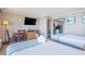 Bright hotel suite bedroom with two beds, workspace, and kitchenette at 6900 N Ocean Blvd. # 812, Myrtle Beach, SC 29572