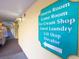 Bright hallway with a sign pointing to the fitness room, game room, ice cream shop, guest laundry, gift shop, and elevator at 6900 N Ocean Blvd. # 812, Myrtle Beach, SC 29572
