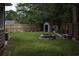 Fenced backyard with stone fire pit, storage shed, and wooded perimeter at 104 Sprucewood Ct., Myrtle Beach, SC 29588