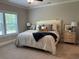 A well-lit bedroom with neutral walls, carpet, and a plush king-size bed at 3131 Tiger Tail Rd., Conway, SC 29526
