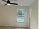 Bedroom with a window overlooking a green area with trees, with carpet flooring and a ceiling fan at 74 Greentown Rd., Georgetown, SC 29440