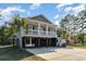 Charming elevated home with gray siding, white railings, and ample parking space underneath at 100 Lure Ct., Conway, SC 29526