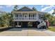 Inviting two-story home featuring gray siding, white columns and railings, and a spacious carport at 100 Lure Ct., Conway, SC 29526