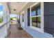 Charming front porch with wood flooring, white pillars, and a view of the lush landscape at 100 Lure Ct., Conway, SC 29526