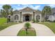 Charming home with a circular driveway, lush tropical landscaping, and manicured lawn at 202 Ave. Of The Palms, Myrtle Beach, SC 29579
